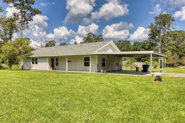 back of house with a carport and a lawn