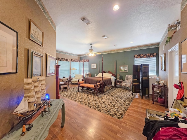 404 Pintail Ln, Orange, TX 77630 - bedroom with wood finished floors, a textured ceiling, a textured wall, crown molding, and a ceiling fan