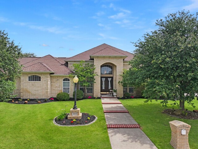 404 Pintail Ln, Orange, TX 77630 - view of front of house with a front lawn, brick siding, and roof with shingles
