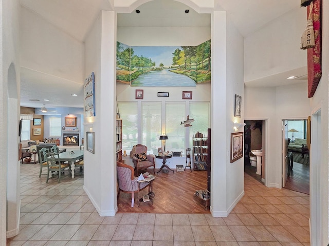404 Pintail Ln, Orange, TX 77630 - foyer with a high ceiling, light tile patterned flooring, baseboards, ceiling fan, and a glass covered fireplace