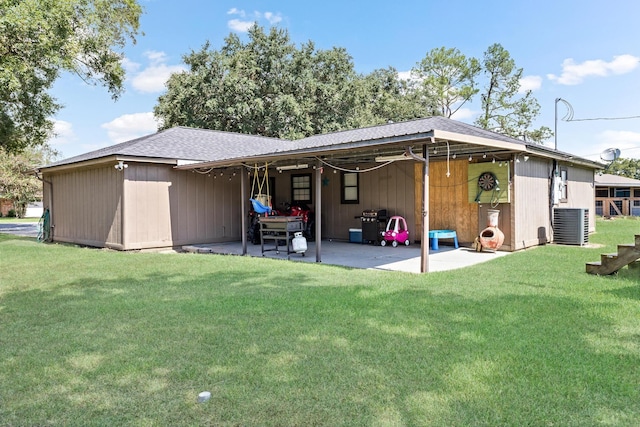 rear view of property featuring a yard, cooling unit, and a patio area