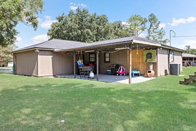 rear view of property featuring a yard, cooling unit, and a patio area