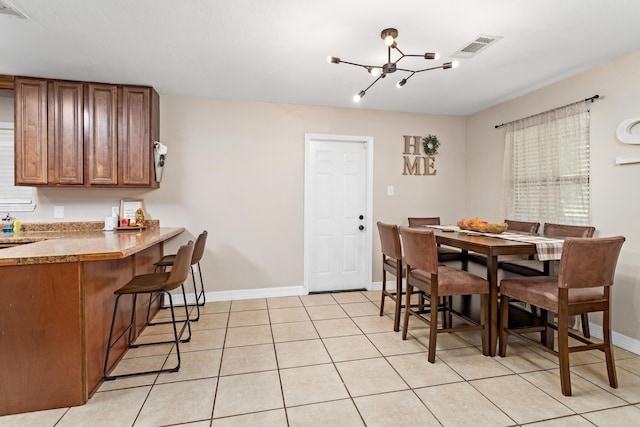 dining space featuring light tile patterned floors and a notable chandelier