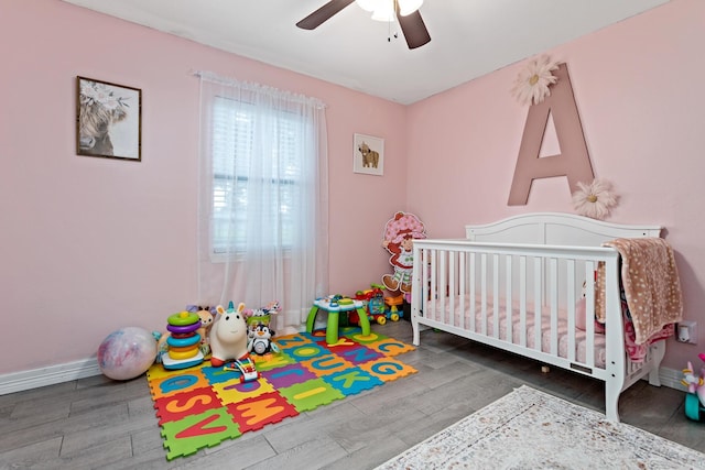 bedroom featuring ceiling fan and a crib