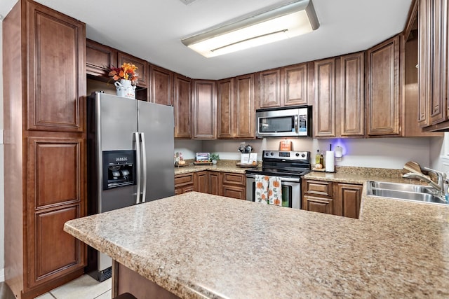 kitchen featuring kitchen peninsula, stainless steel appliances, light tile patterned flooring, and sink