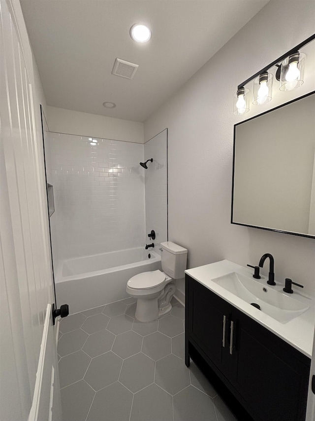 full bathroom featuring toilet, tiled shower / bath combo, tile patterned floors, and vanity