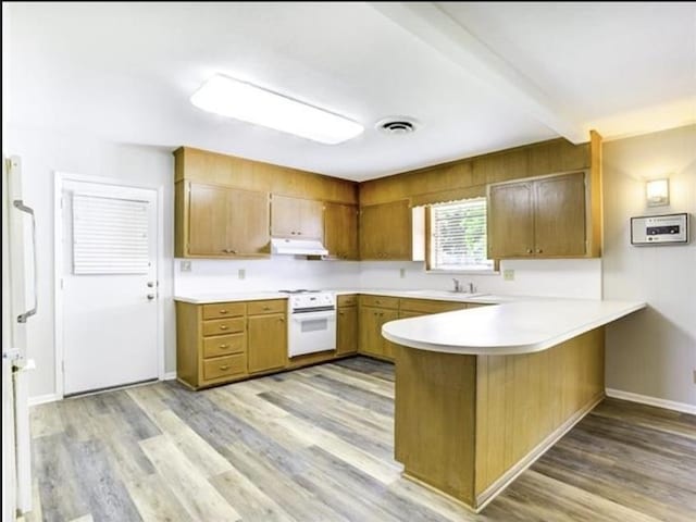 5390 Swallow Dr, Beaumont, TX 77707 - kitchen with a peninsula, light wood-style flooring, white electric stove, under cabinet range hood, and visible vents