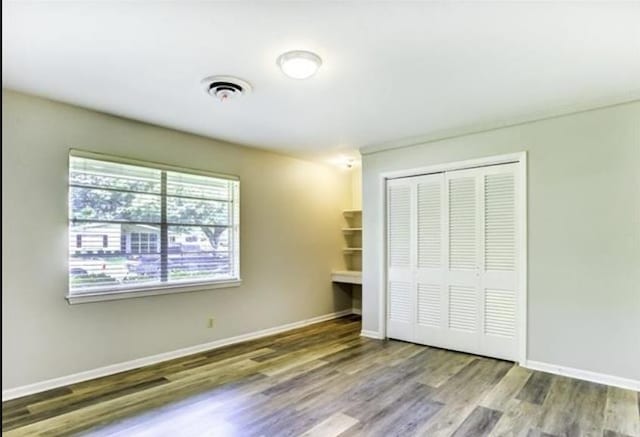 5390 Swallow Dr, Beaumont, TX 77707 - unfurnished bedroom with a closet, wood finished floors, baseboards, and visible vents
