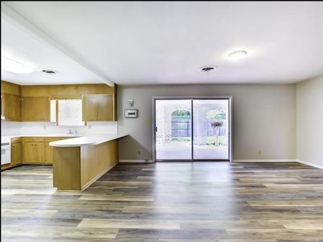5390 Swallow Dr, Beaumont, TX 77707 - kitchen with light countertops, a peninsula, wood finished floors, and baseboards