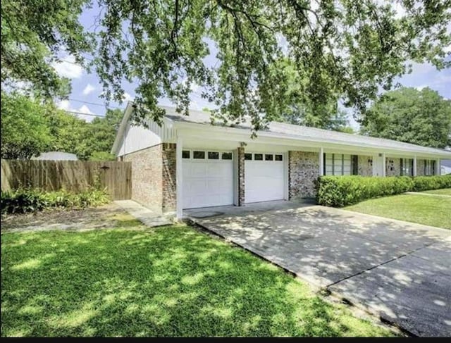 5390 Swallow Dr, Beaumont, TX 77707 - view of front of property featuring driveway, a front lawn, fence, and a garage
