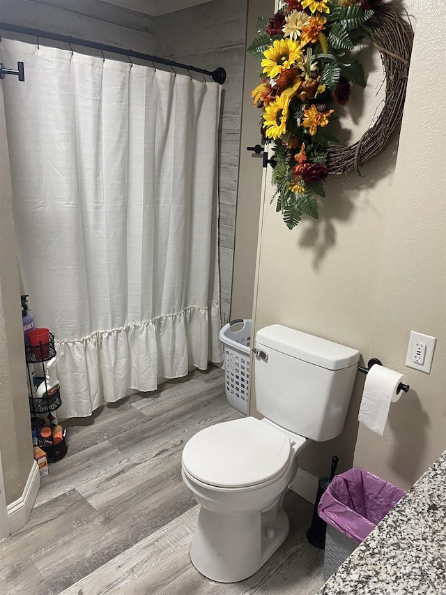 6033 Stones Throw Dr, Silsbee, TX 77656 - bathroom featuring wood finished floors, toilet, a shower with shower curtain, and baseboards
