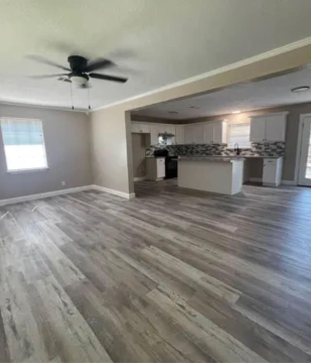 6033 Stones Throw Dr, Silsbee, TX 77656 - unfurnished living room featuring baseboards, dark wood finished floors, and a ceiling fan