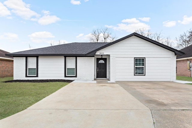 single story home with driveway, brick siding, a shingled roof, and a front yard