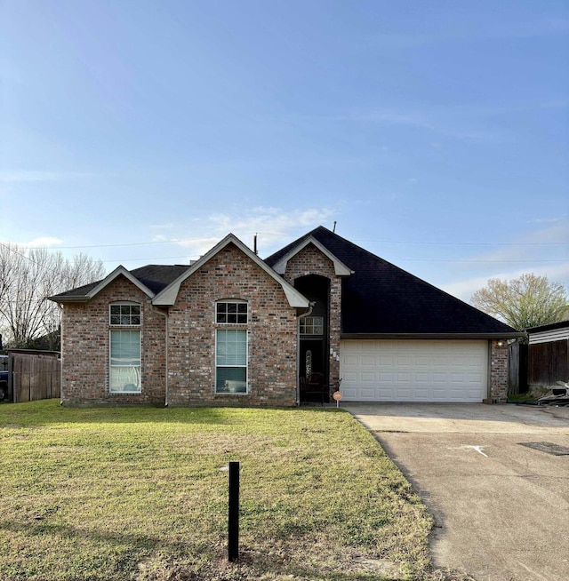 ranch-style home with brick siding, fence, a garage, driveway, and a front lawn