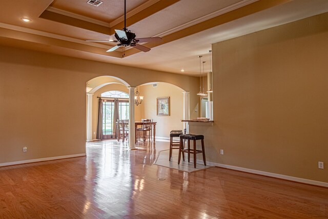 unfurnished room featuring french doors, a raised ceiling, crown molding, ceiling fan, and light wood-type flooring