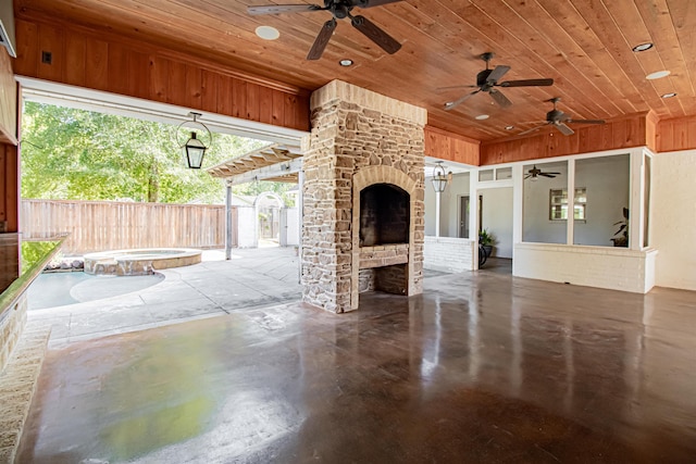 view of patio featuring a fireplace and an in ground hot tub