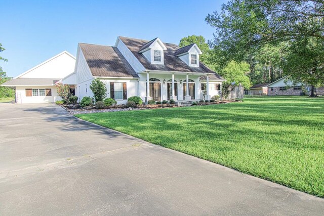 cape cod house featuring a porch and a front yard