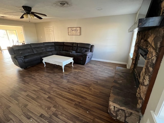 living room with ceiling fan, a fireplace, and dark hardwood / wood-style floors