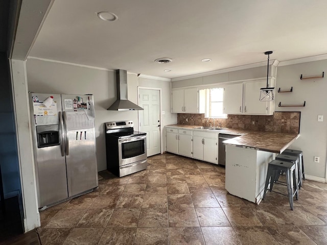 kitchen with white cabinetry, wall chimney exhaust hood, hanging light fixtures, a breakfast bar, and appliances with stainless steel finishes