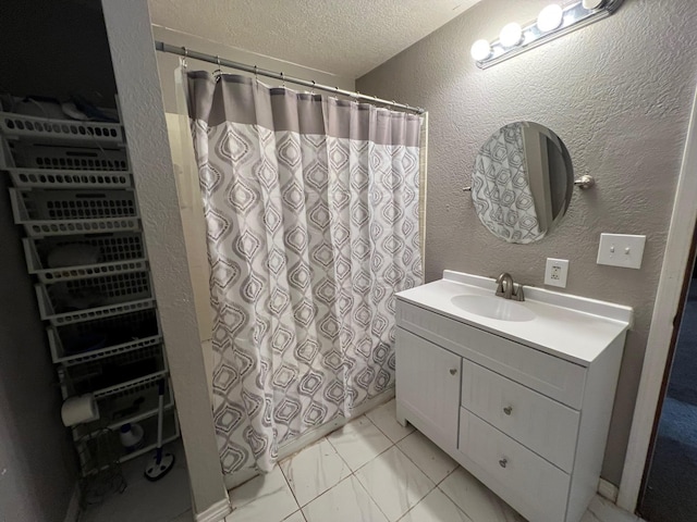 bathroom featuring vanity, a textured ceiling, and tile patterned flooring