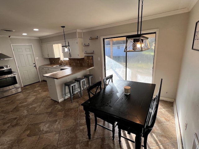 dining area with crown molding and sink