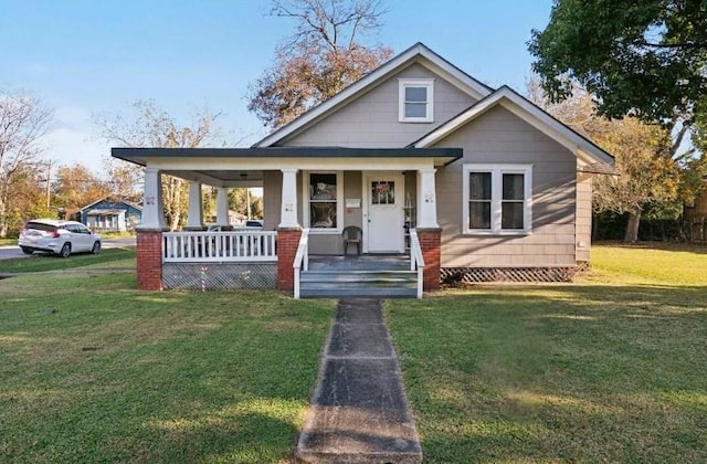 bungalow-style home featuring covered porch and a front yard