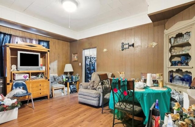 sitting room with hardwood / wood-style floors and wood walls