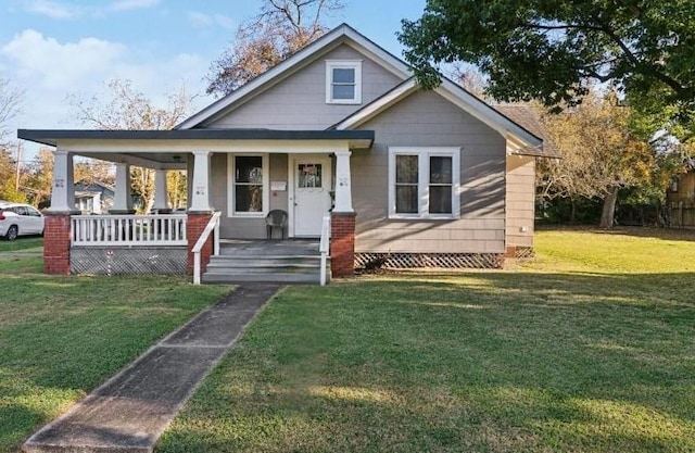 bungalow featuring covered porch and a front lawn