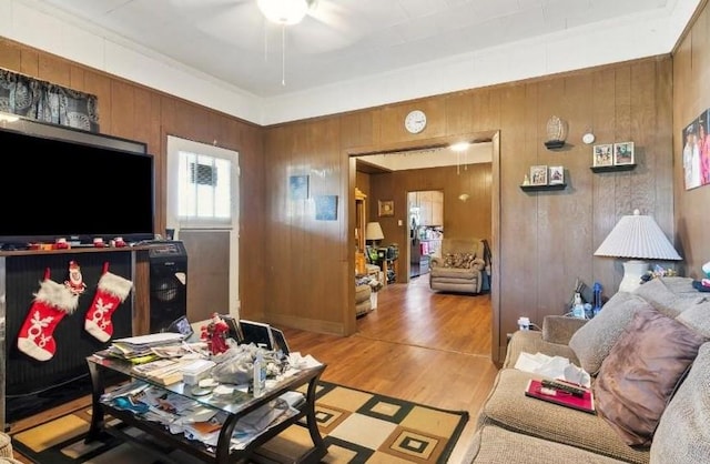 living room featuring wood walls, ceiling fan, and hardwood / wood-style flooring