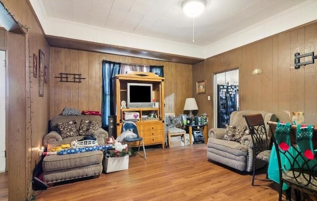 sitting room with hardwood / wood-style floors and wooden walls