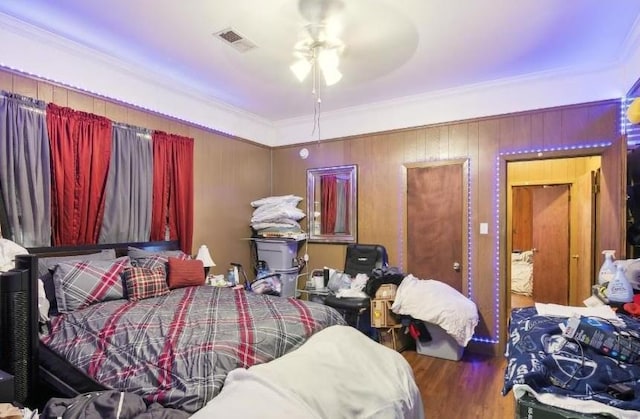 bedroom with ceiling fan, wood-type flooring, and ornamental molding