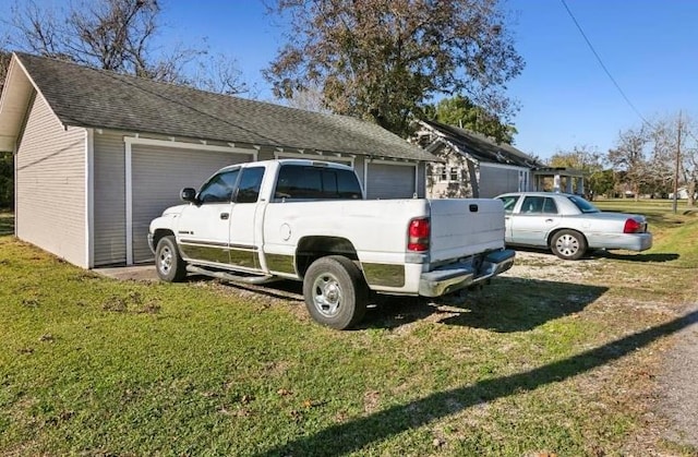 view of property exterior featuring a garage, a yard, and an outbuilding