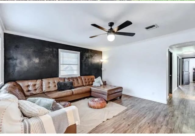 living room featuring hardwood / wood-style flooring, ceiling fan, and ornamental molding