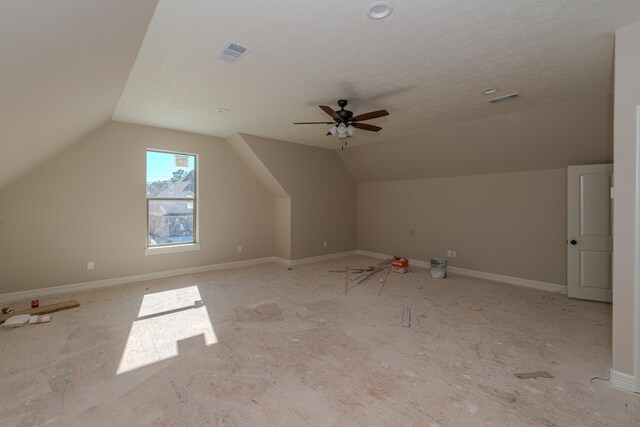 bonus room with ceiling fan, a textured ceiling, and vaulted ceiling