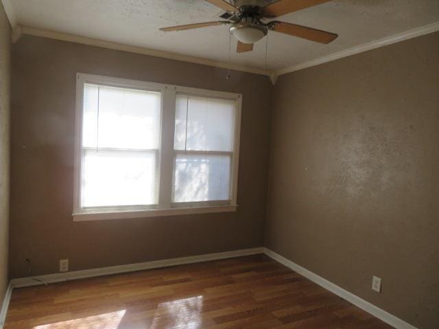 unfurnished room with crown molding, wood-type flooring, ceiling fan, and a healthy amount of sunlight