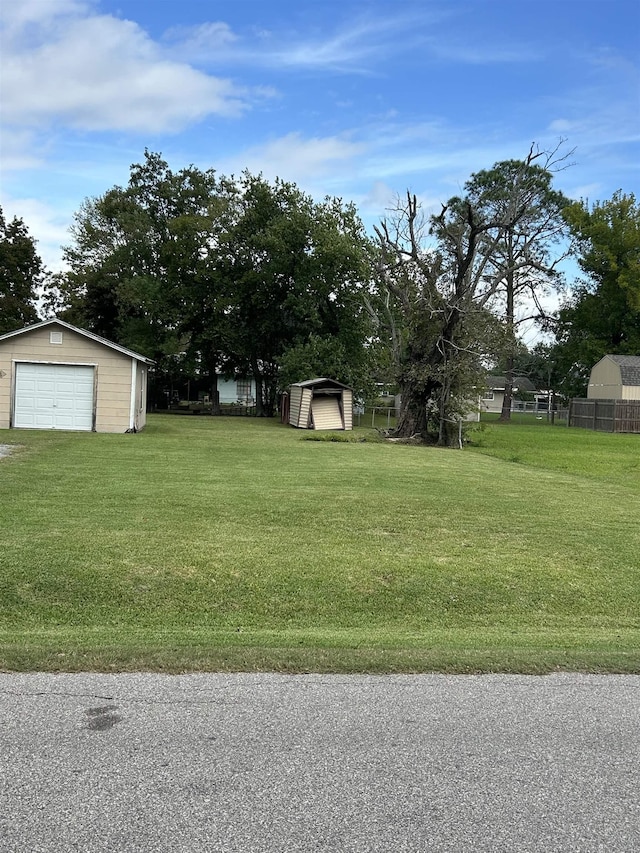 view of yard featuring a garage and a storage shed