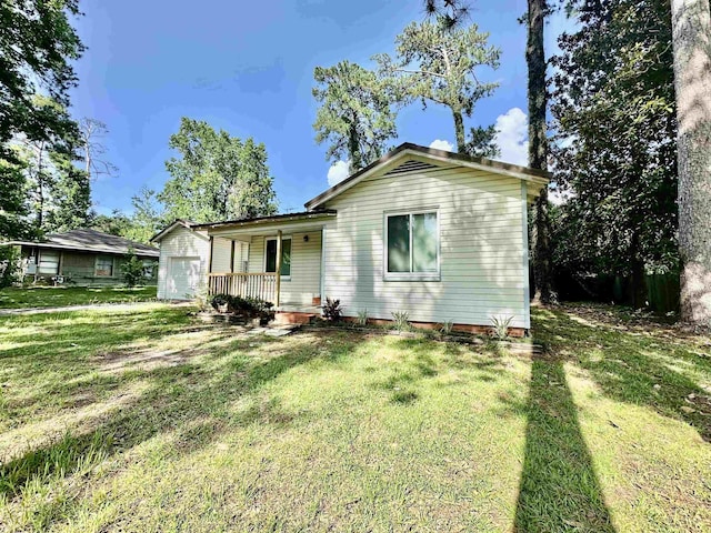 312 Temple, Woodville, TX 75979 - back of property with covered porch, a yard, and an attached garage