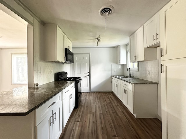 312 Temple, Woodville, TX 75979 - kitchen with black appliances, dark wood-style floors, decorative backsplash, and white cabinets