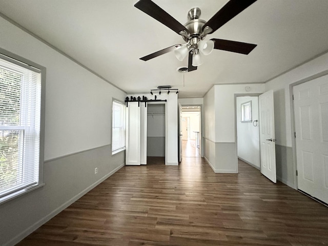 312 Temple, Woodville, TX 75979 - unfurnished bedroom featuring dark wood-style floors, a ceiling fan, and a closet