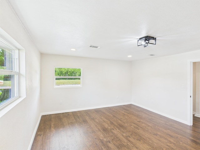 empty room featuring dark wood finished floors, baseboards, visible vents, and recessed lighting