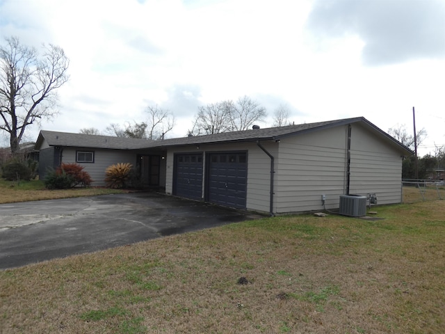 view of front of home with a garage, central AC, and a front yard