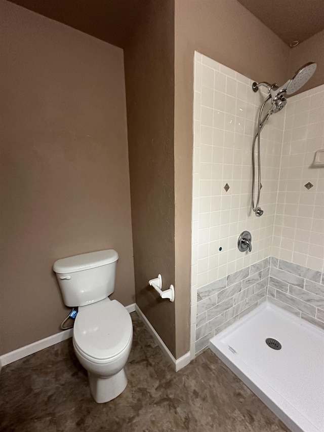 bathroom featuring toilet and tiled shower