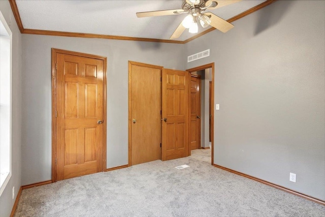 unfurnished bedroom featuring ceiling fan, light colored carpet, lofted ceiling, and crown molding