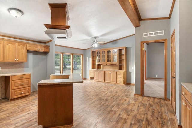 kitchen featuring ornamental molding, a textured ceiling, ceiling fan, lofted ceiling with beams, and light hardwood / wood-style flooring