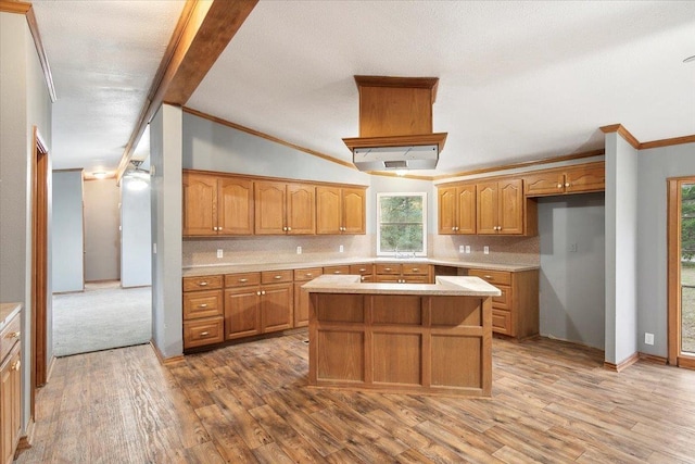 kitchen with backsplash, vaulted ceiling with beams, a center island, and wood-type flooring