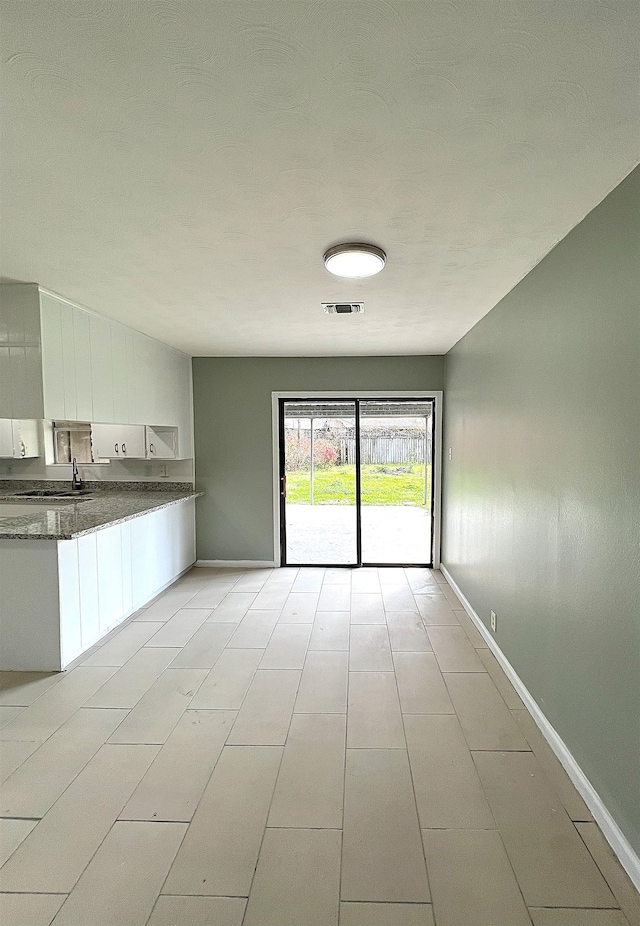 interior space with visible vents, baseboards, and a sink