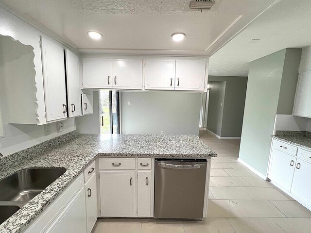 kitchen featuring dishwasher, a peninsula, visible vents, and white cabinetry