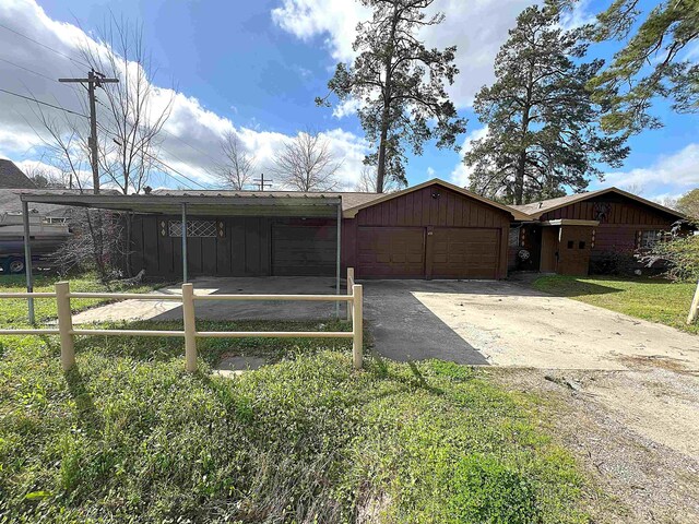 exterior space featuring a garage, a carport, board and batten siding, and concrete driveway