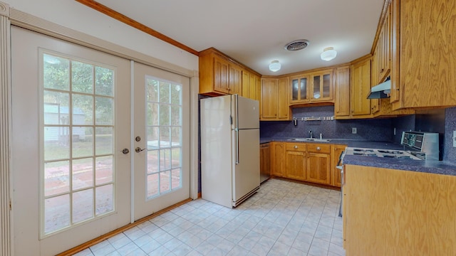 kitchen featuring french doors, sink, backsplash, crown molding, and white fridge