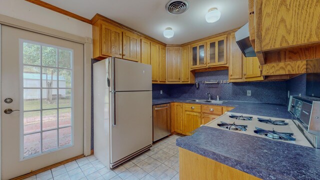 kitchen with sink, dishwasher, tasteful backsplash, white refrigerator, and exhaust hood